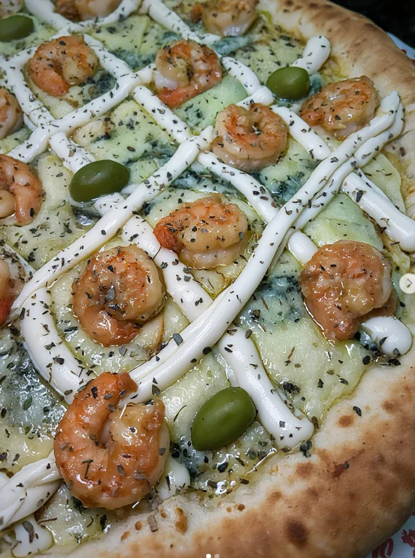 Detalhe do camarão e do queijo na pizza da casa